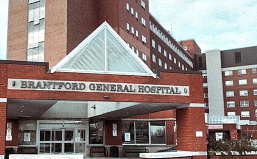 The entrance of Brantford General Hospital, with a red brick facade and a large sign above the main doors under a triangular white canopy, serves as a hub for health care in Canada, including treatment for Lyme disease and other tick-borne illnesses.