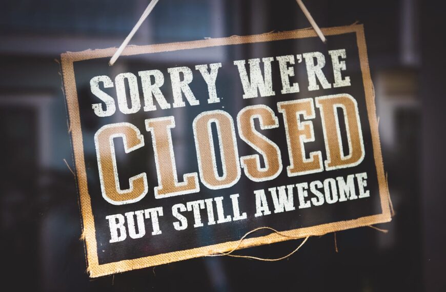 A sign hanging on a door reads, "Sorry we're closed but still awesome," in bold, white, and gold letters on a black background, marking clinic closures on Thursday evening.